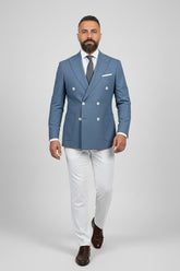 Man in midnight petrol double-breasted suit with white trousers, ideal for upscale events.